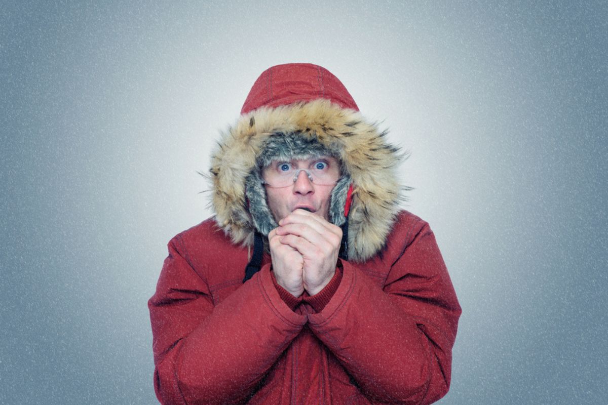 Man in winter clothes warming hands, cold.