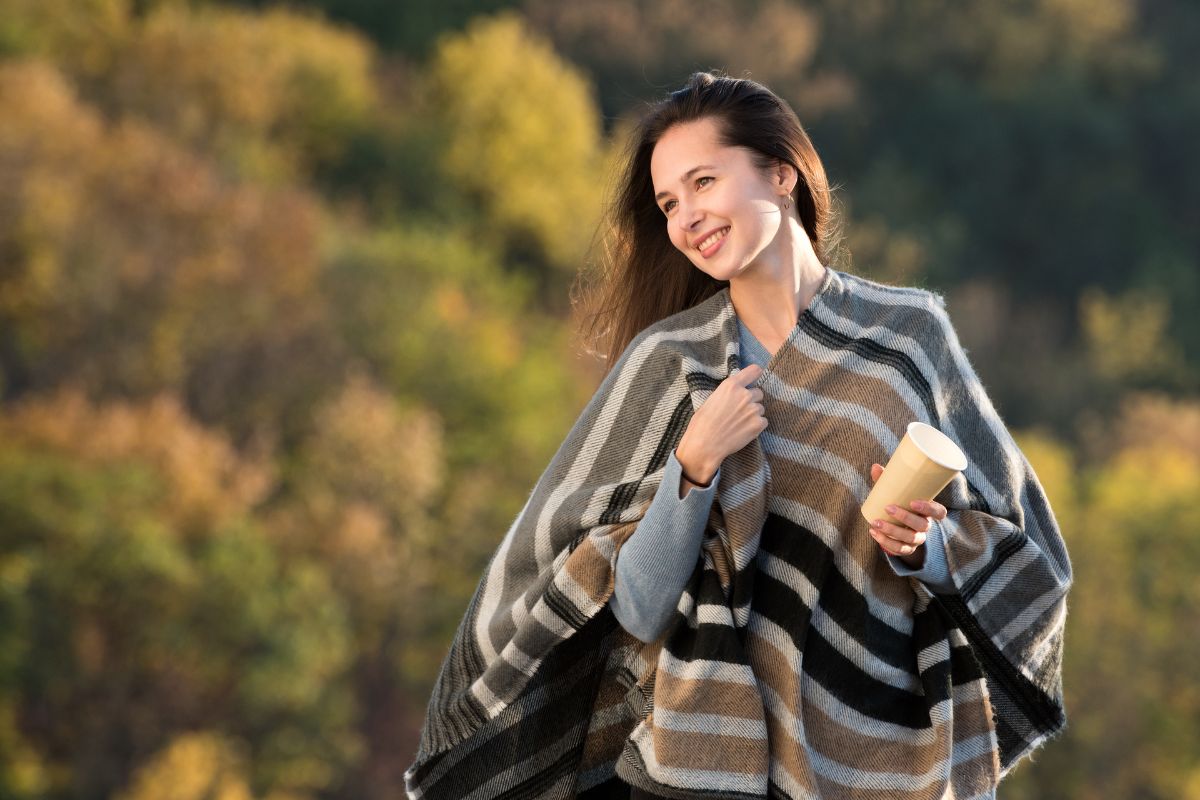 Woman in poncho relaxing outdoors.