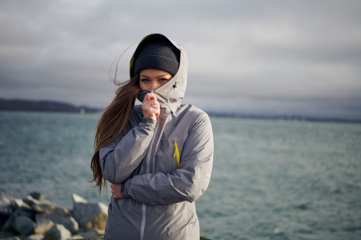 Young beautiful woman wearing rain jacket in cold weather.
