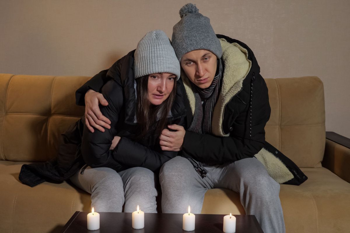 Sad frozen couple in warm heated jacket.